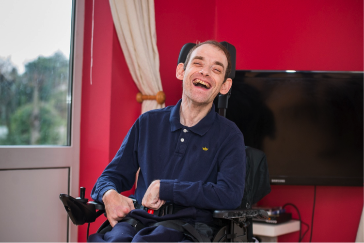 Man laughing and smiling in wheelchair | Harpenden Mencap