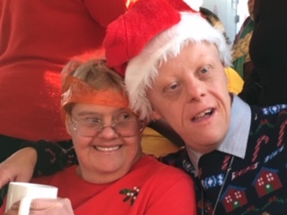 Two tenants wearing Christmas hats and smiling | Harpenden Mencap