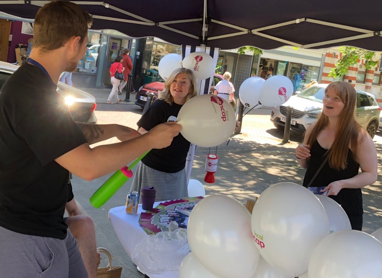 One man and two women holding balloons | Harpenden Mencap